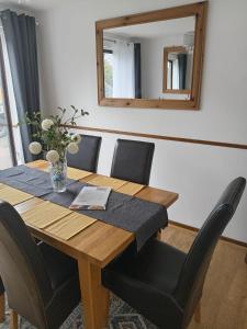 a dining room table with black chairs and a mirror at Rowan House Rotherham in Rotherham