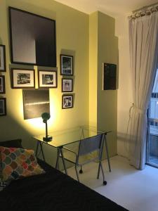 1 dormitorio con mesa de cristal y TV en la pared en Quarto super especial no Rio en Río de Janeiro