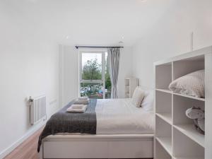 a white bedroom with a bed and a window at Pass the Keys Spacious Apartment in Camberwell in London