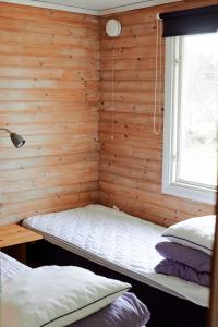 Habitación con cama en una pared de madera. en Valleviken Hotell en Valleviken