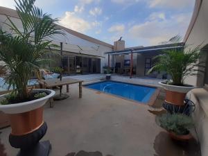 eine Terrasse mit Pool, Tisch und Pflanzen in der Unterkunft Lerato's in Vanderbijlpark
