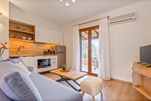 una sala de estar con un sofá y una mesa en Lola Apartments, en Liapades
