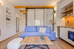 a living room with a blue couch and a table at Lola Apartments in Liapades