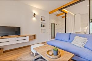 Una sala de estar con un sofá azul y una mesa. en Lola Apartments, en Liapades