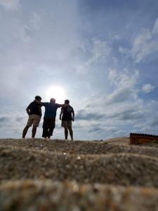 un grupo de tres hombres parados en la cima de una colina en Kondominium pantai crita by lukman, en Sukarame