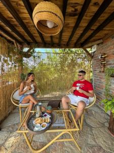 un uomo e una donna seduti su un patio di Glamping el nido a Curití