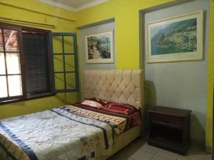 1 dormitorio con 1 cama en una habitación con paredes amarillas en Kondominium pantai crita by lukman, en Sukarame