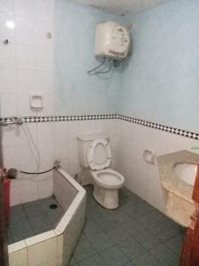 a bathroom with a toilet and a phone on the wall at Kondominium pantai crita by lukman in Sukarame