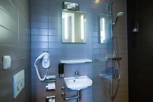 a bathroom with a sink and a phone on the wall at Hotel Vossius Vondelpark in Amsterdam