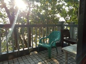 una silla verde y un banco en un porche en Kondominium pantai crita by lukman, en Sukarame