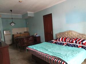 1 dormitorio con cama, mesa y cocina en Kondominium pantai crita by lukman, en Sukarame