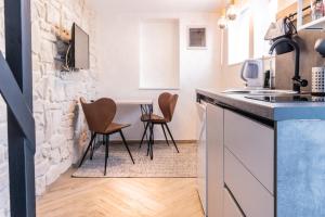 a kitchen with a counter and chairs in a room at L&B amphitheater apartments in Pula