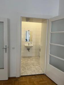 W łazience znajduje się umywalka, toaleta i lustro. w obiekcie 8-9Sam Apartment vienna w Wiedniu