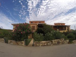 a house with flowers in front of a building at Residence Spiaggia Bianca in Golfo Aranci