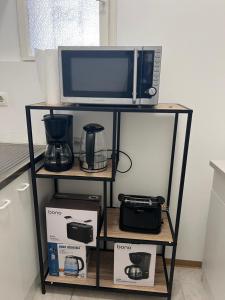 kuchenka mikrofalowa i inne urządzenia na półce w kuchni w obiekcie 8-9Sam Apartment vienna w Wiedniu