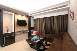 uma sala de estar com um sofá e uma televisão em The Autograph Inn em Siliguri