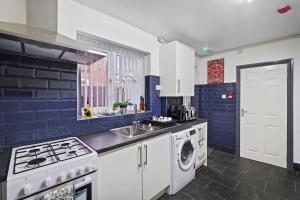 a blue and white kitchen with a washer and dryer at Stunning 5 bedroom home Long stays contactors welcome in Birmingham