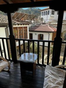 a glass table on a balcony with a view of a house at Hotel Mangalemi in Berat