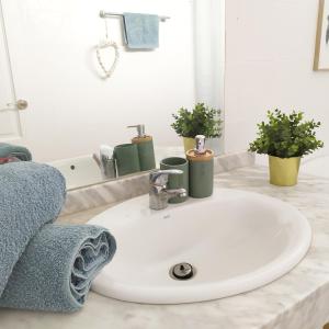 bagno con lavandino bianco e specchio di oasismarverdemar a Corralejo