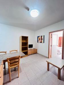 a living room with a table and a television at Garden View Apartment No 40 in Tal-Franċiż