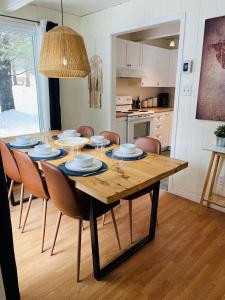 Le Jackrabbit Orford Domaine Cheribourg في Orford: غرفة طعام مع طاولة وكراسي ومطبخ