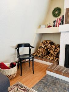 Le Jackrabbit Orford Domaine Cheribourg في Orford: كرسي أسود في غرفة المعيشة مع موقد