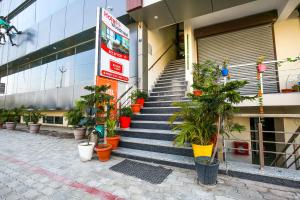 a building with stairs and potted plants in front of it at Woodcrust Lodge in Udaipur