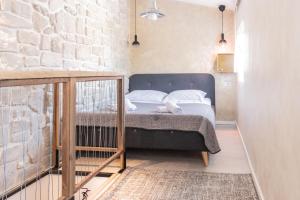 a bed in a room with a brick wall at L&B amphitheater apartments in Pula