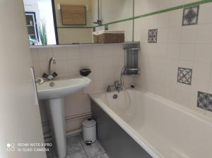 een badkamer met een wastafel en een bad naast een wastafel bij LE BARCARES in Le Barcarès
