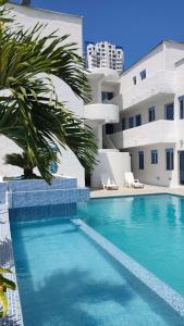 a large swimming pool next to a white building at Moderno departamento vacacional. in Tonsupa