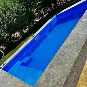 a large blue swimming pool in a yard at ENCANTADORA Casa de Campo - Ica in Ica