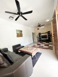 uma sala de estar com um sofá e uma ventoinha de tecto em Baiduri Homestay em Kota Tinggi