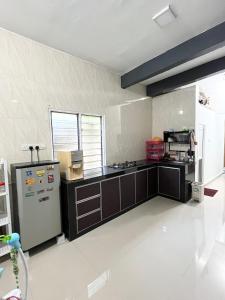 uma grande cozinha com um fogão e um frigorífico em Baiduri Homestay em Kota Tinggi