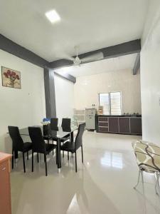 uma cozinha e sala de jantar com mesa e cadeiras em Baiduri Homestay em Kota Tinggi