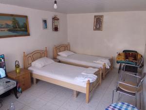 a room with two beds and a chair in it at Te MuzzeU Hostel in Berat