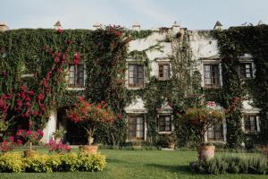 een met klimop overdekt gebouw met bloemen in de tuin bij Hacienda Acamilpa in Acamilpa