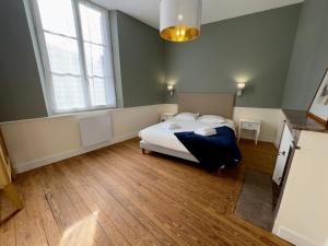 een slaapkamer met een bed en 2 ramen bij Appartement Le Corneille centre ville climatisé in Saumur