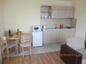 cocina con mesa y nevera blanca en Stephanovy Guest House, en Sozopol