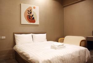 a hotel room with a bed with towels on it at 聖水洞民宿성수동 in Tainan
