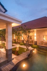 a backyard with a swimming pool and a house at The Cozy Haven Sanur in Sanur