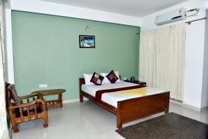 - une chambre avec un lit et une chaise dans l'établissement SAS Apartment, à Bangalore
