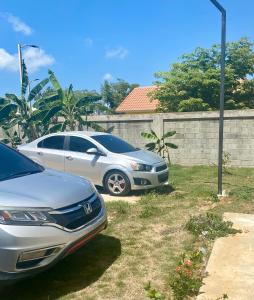 a couple of cars parked in a yard at Acogedor apartamento amueblado in Los Paredones