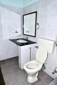 a bathroom with a white toilet and a sink at SAS Apartment in Bangalore
