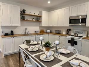 a kitchen with white cabinets and a table and chairs at Coin paisible au large de Québec in Quebec City