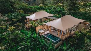 an overhead view of a house with a pool and umbrellas at Nayara Tented Camp in Fortuna