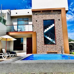 a house with a swimming pool next to a building at ENCANTADORA Casa de Campo - Ica in Ica