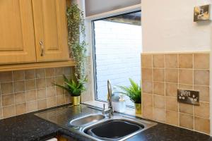 a kitchen counter with a sink and a window at Delightful 2 bed town centre house, sleeps 4 in Barnsley