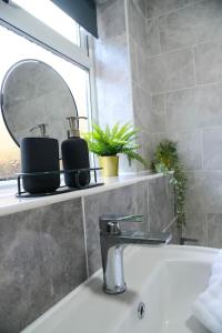 a bathroom with a sink and a mirror on a shelf at Delightful 2 bed town centre house, sleeps 4 in Barnsley