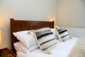 Cama con sábanas y almohadas blancas en Delightful 2 bed town centre house, sleeps 4, en Barnsley
