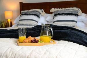 bandeja de fruta y zumo de naranja en una cama en Delightful 2 bed town centre house, sleeps 4, en Barnsley